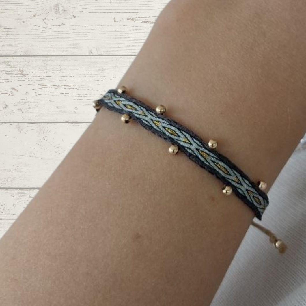 Pulsera de seda, orilla gris oscuro, con dibujos gris y oro